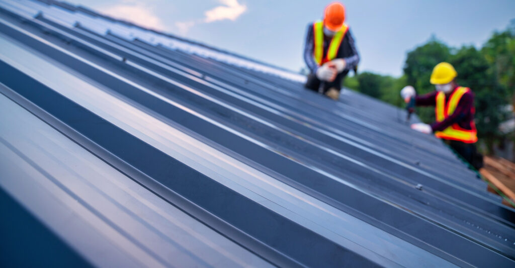 Roofers installing metal roof